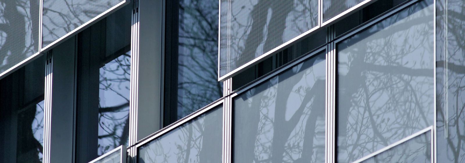Detail der neuen Fassade mit beweglichen Brüstungselementen aus Glas-Streckmetall als Sonnenschutz.