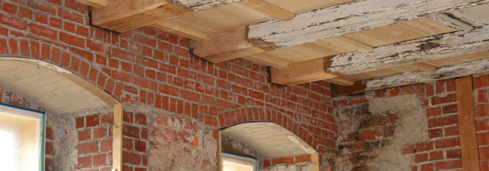 Sanierte Holzbalkendecke in einem Barockschloss – die geschädigten Holzbalkenköpfe müssen unbedingt erneuert und das Außenmauerwerk aus Vollziegeln saniert werden