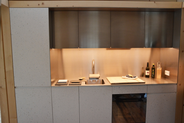 Auf dem Bild ist eine Küche mit weißen Fronten mit bunten Flecken zu sehen.