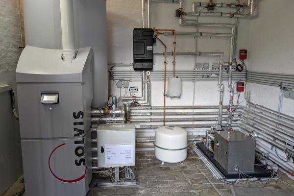 Fig.3: Heating room with heating water storage tank with 950 litre volume and integrated heat-ing module (gas condensing boiler) (left) and booster heat pump (right)